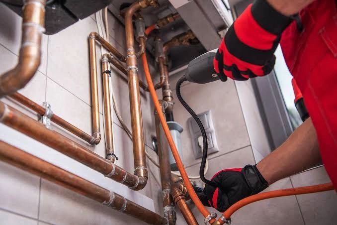 HVAC technician working on copper pipes